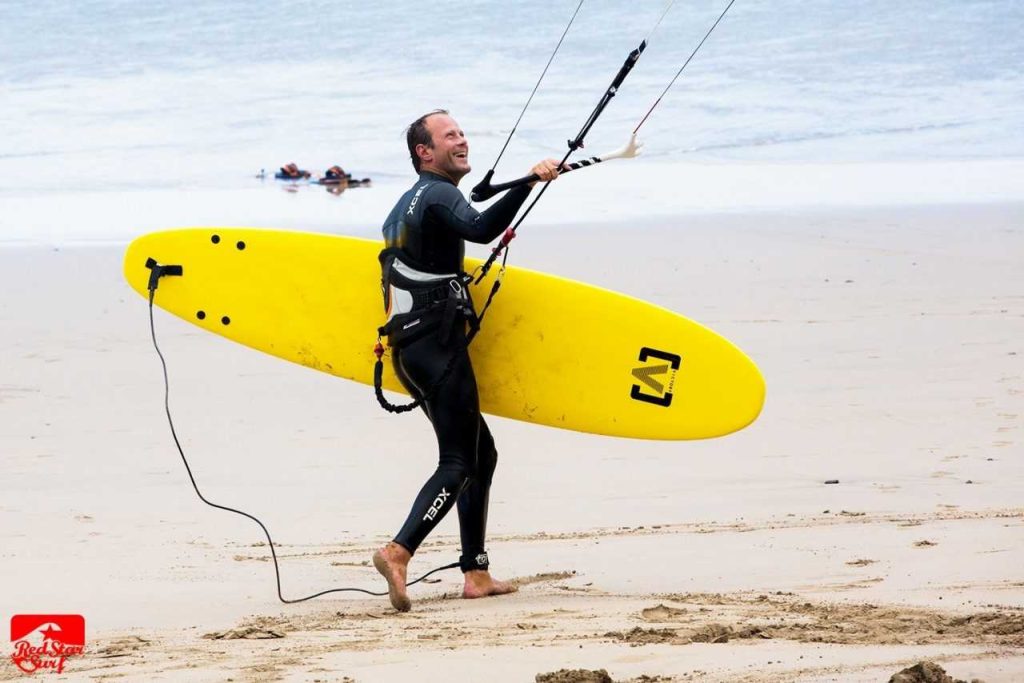 Kitesurfer z żółtą deską na plaży Famara