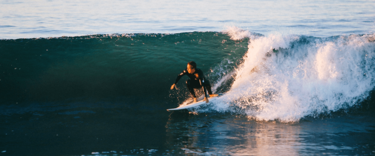 Surfer na fali na plaży Famara, Lanzarote, zimą