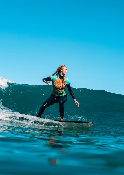 Średnio zaawansowany surfer na zielonej fali w Famarze