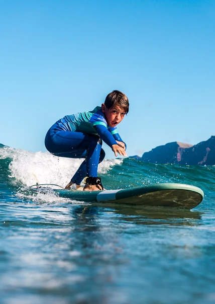 Młody surfer łapie falę w Famarze