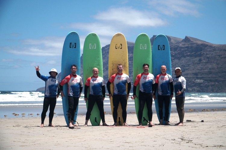Zespół instruktorów Red Star Surf z deskami na plaży Famara