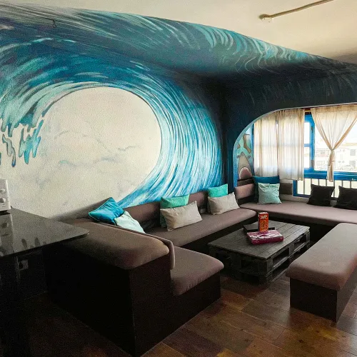 Surf House Casa 55 – salon avec fresque de vague à Famara, Lanzarote