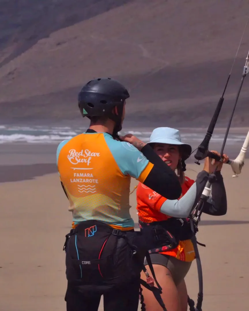 Kite instruktor a student na pláži ve Famaře, Lanzarote