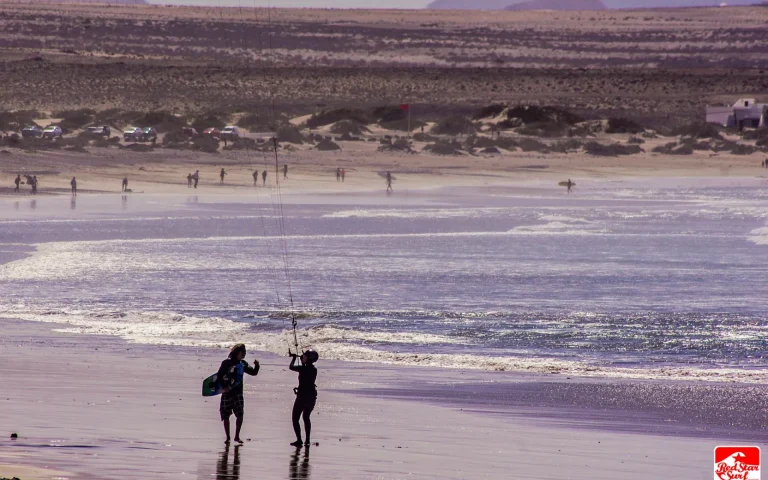Kitesurfer płynie wzdłuż plaży Famara pod klifami Risco, Lanzarote