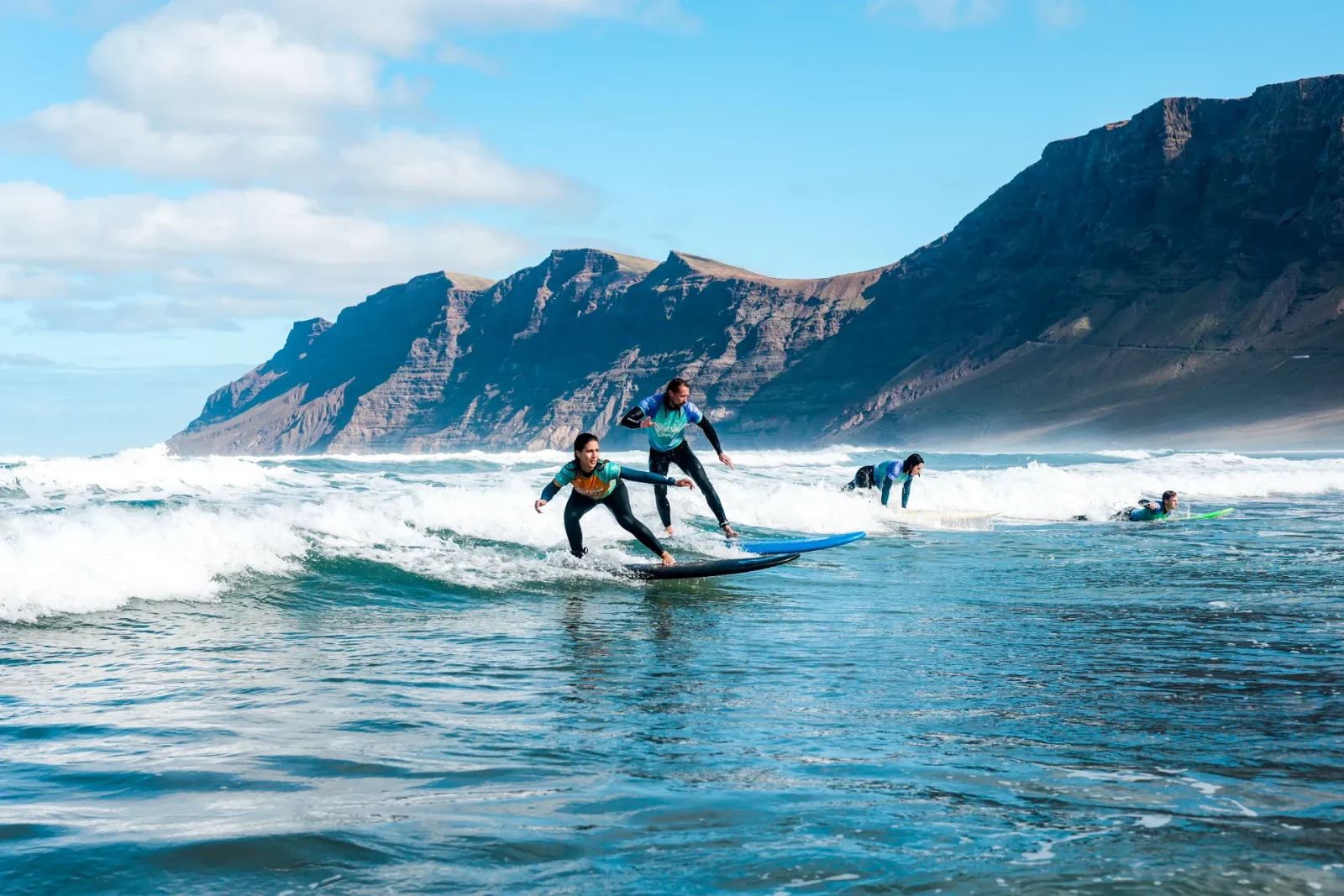 Two surfers riding the same wave at Playa de Famara