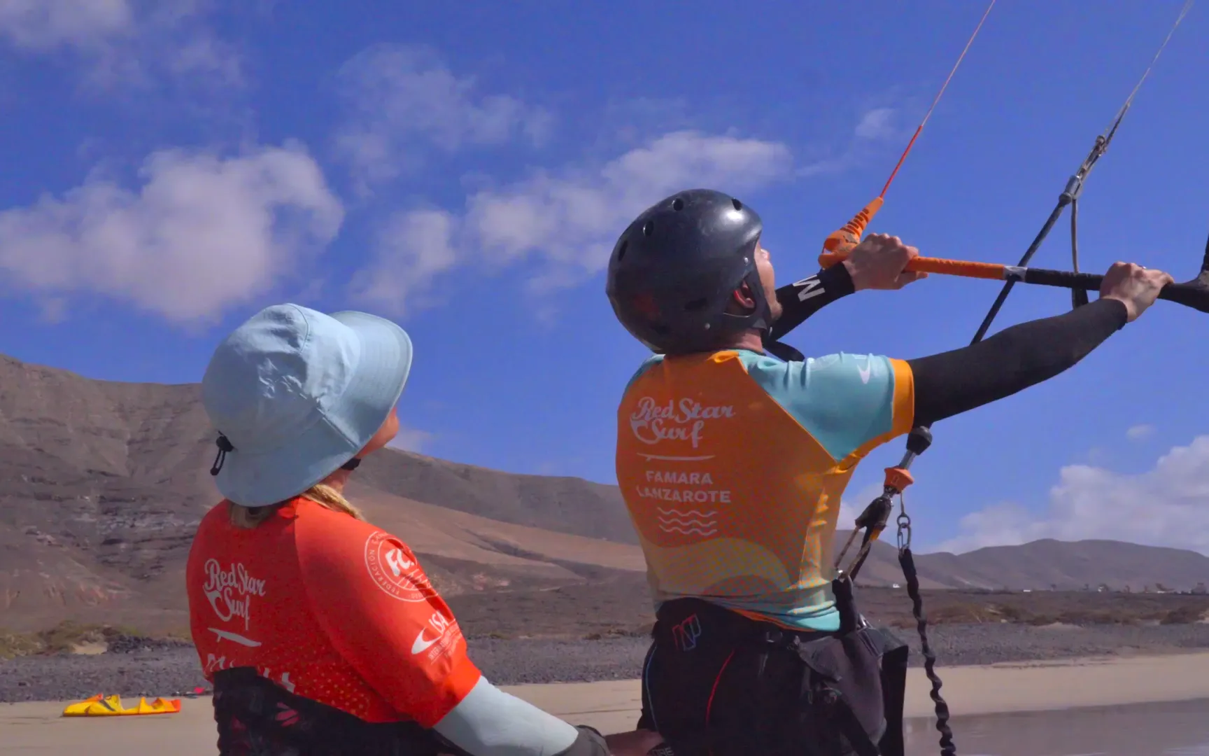 Kitesurfingové vybavení k zapůjčení rozložené na pláži Famara, Lanzarote