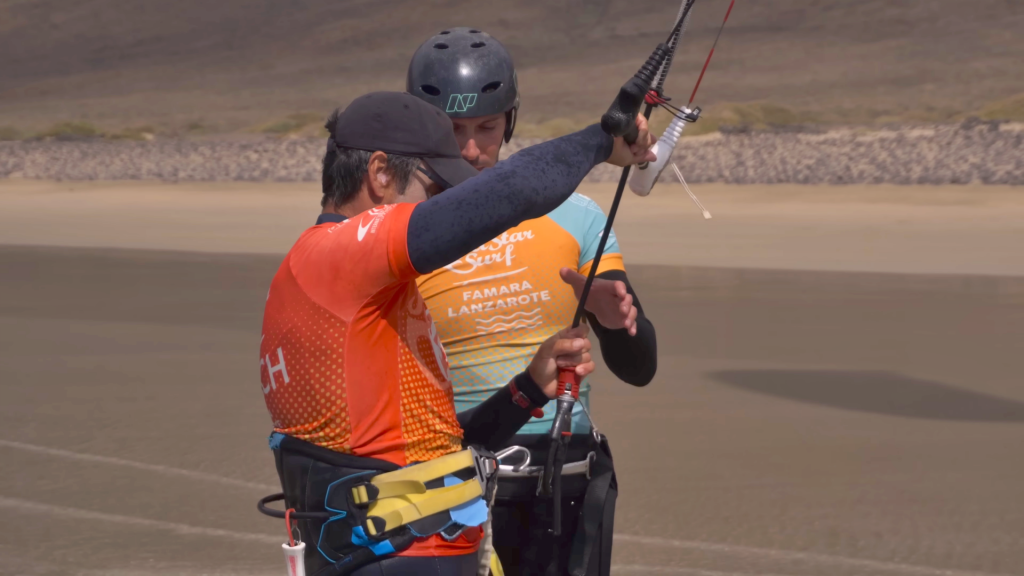 Kursantka kitesurfingu z instruktorem na plaży Famara, Lanzarote