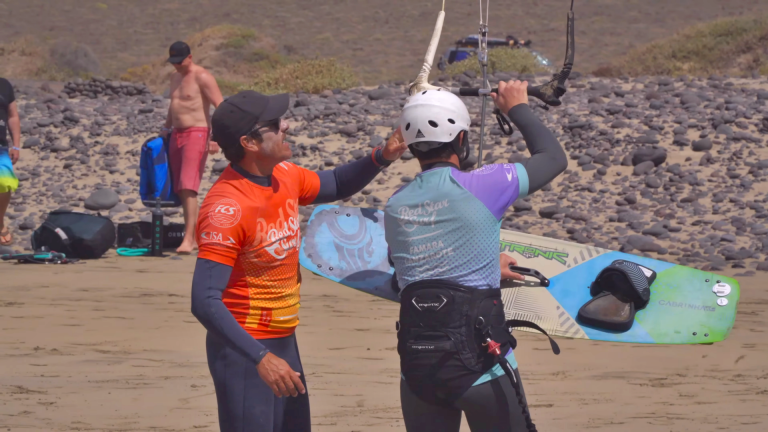 Instruktor kitesurfingu zakłada kask uczniowi na plaży Famara, Lanzarote
